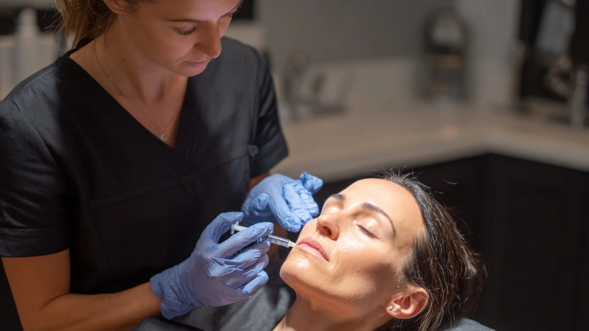 Injector performing jawline filler treatment for lower-face rejuvenation.